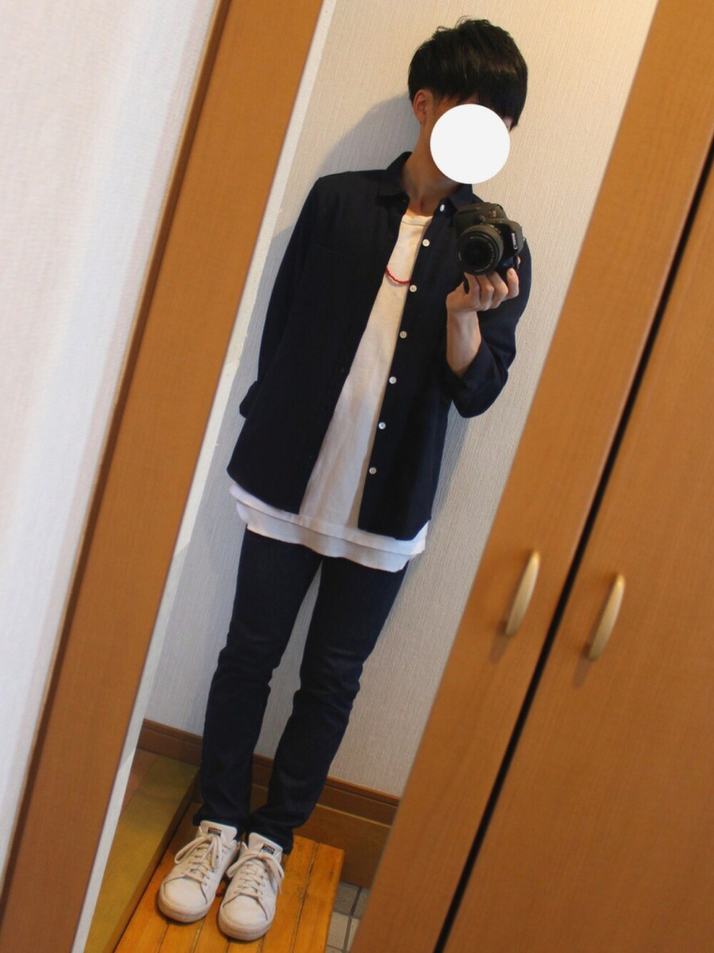 ホワイト系のTシャツ/カットソー、ブルー系のデニムパンツ、ホワイト系のスニーカーを着用したメンズの秋コーディネートの1枚目の写真