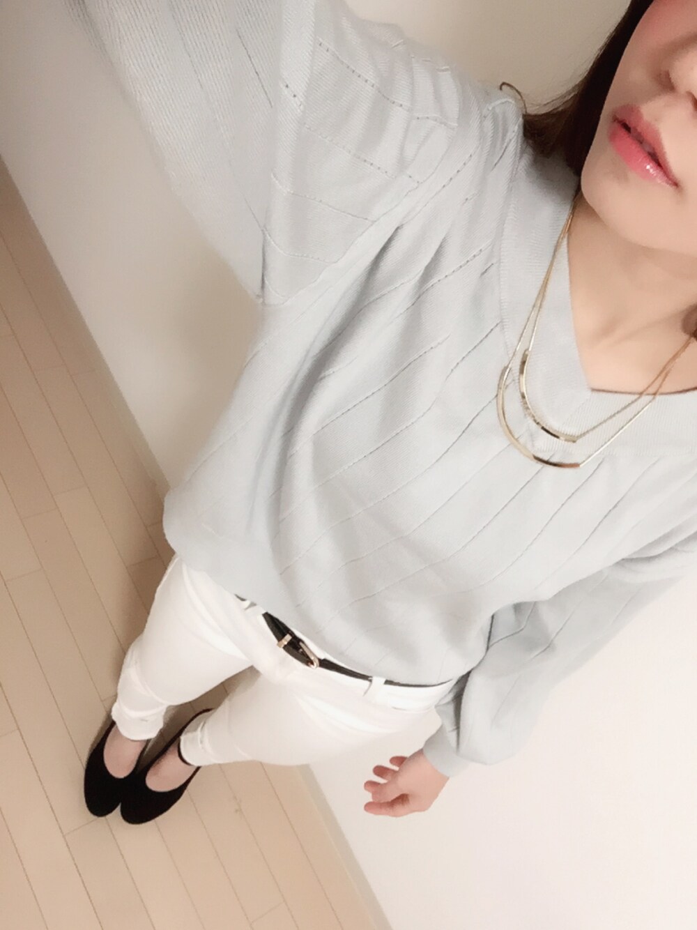 グレー系のニット/セーター、ホワイト系のデニムパンツ、ブラック系のパンプスを着用したレディースの冬コーディネートの1枚目の写真