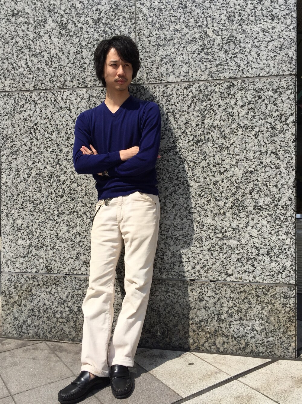 ブルー系のニット/セーター、ブラック系のアナログ腕時計、ブルー系のウォレットチェーンを着用したメンズの春コーディネートの1枚目の写真