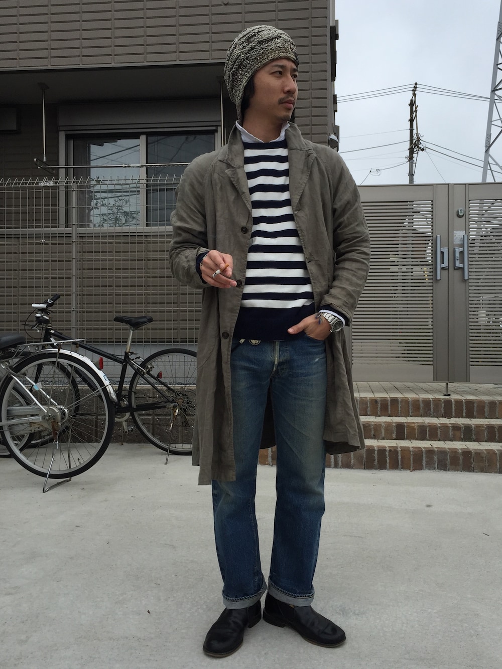 ホワイト系のニット/セーター、ベージュ系のその他アウター、ブルー系のデニムパンツを着用したメンズの春コーディネートの1枚目の写真