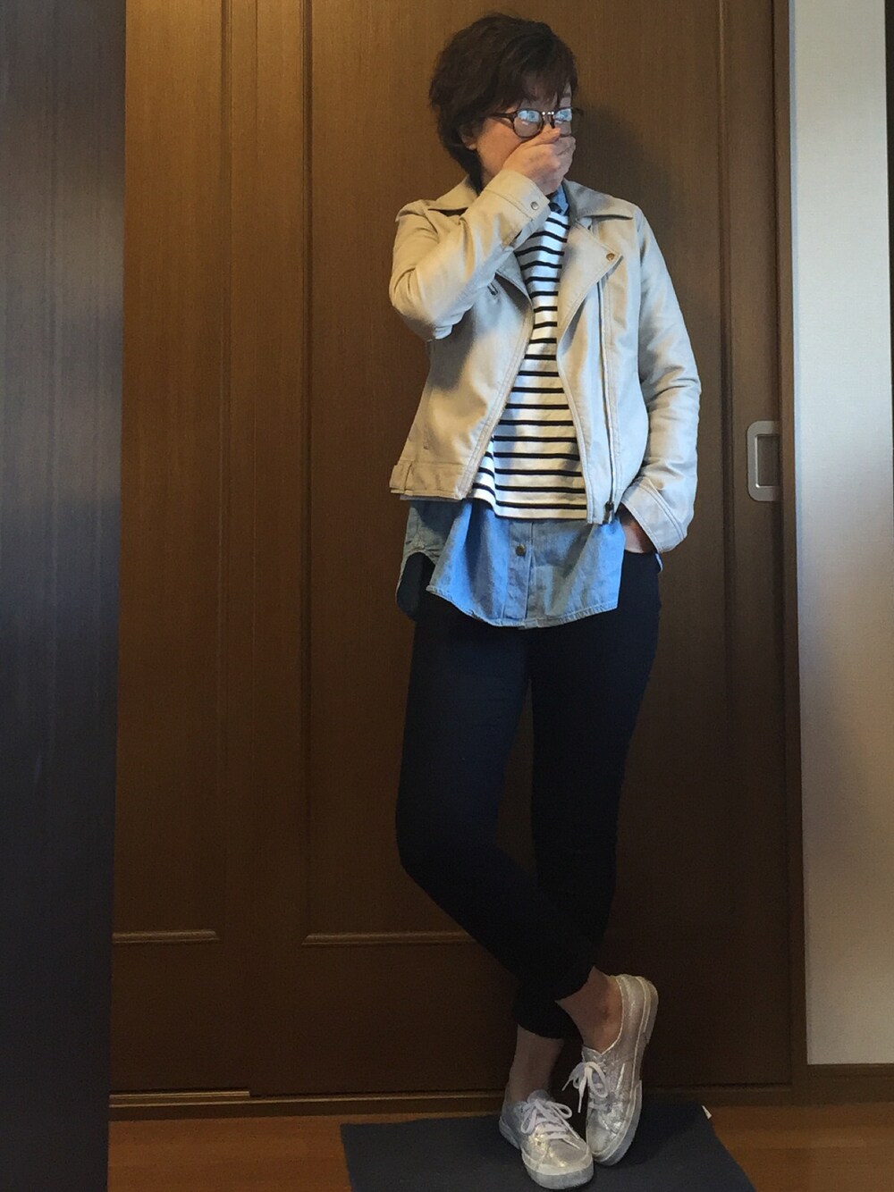 ホワイト系のTシャツ/カットソー、シルバー系のスニーカー、グレー系のライダースジャケットを着用したレディースの春コーディネートの1枚目の写真