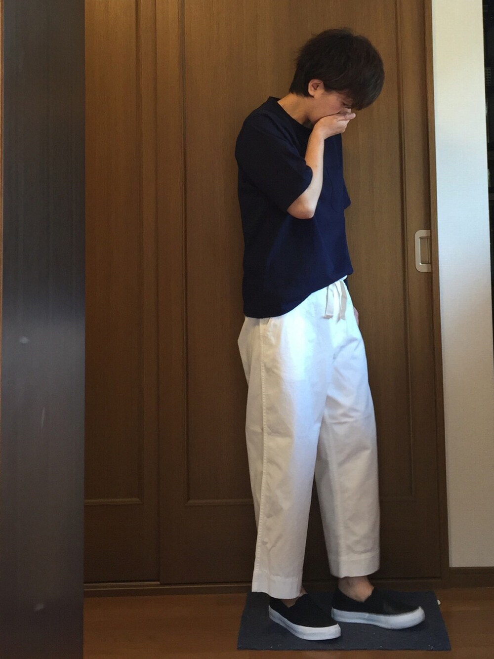 ホワイト系のチノパンツ、ブルー系のTシャツ/カットソー、ブラック系のスリッポンを着用したレディースの春コーディネートの1枚目の写真