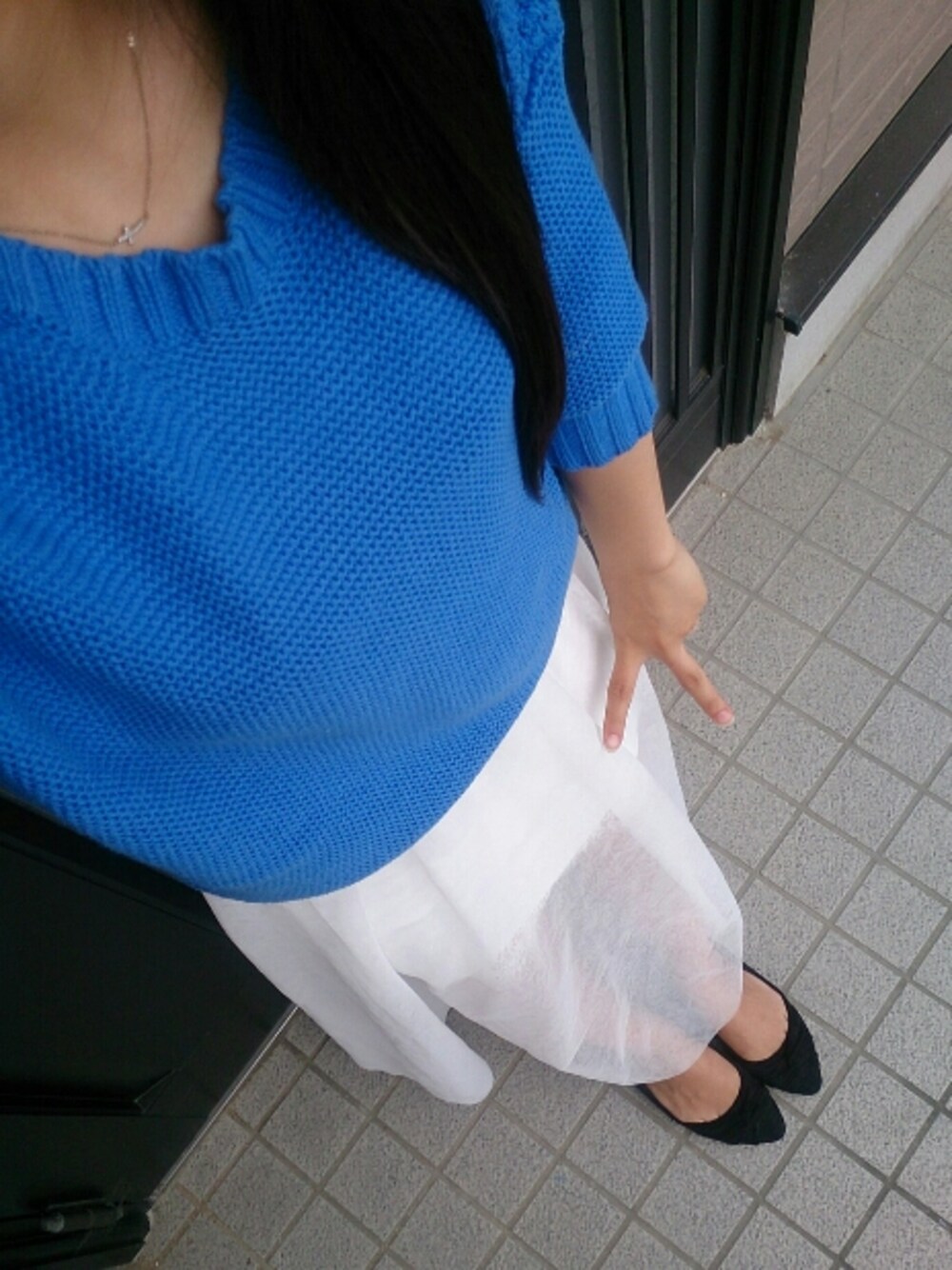 ブルー系のニット/セーター、ホワイト系のスカート、ブラック系のシューズを着用したレディースの春コーディネートの1枚目の写真