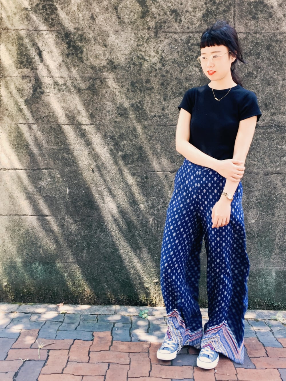 ホワイト系のスニーカー、ホワイト系のTシャツ/カットソー、ゴールド系のメガネを着用したレディースの秋コーディネートの1枚目の写真