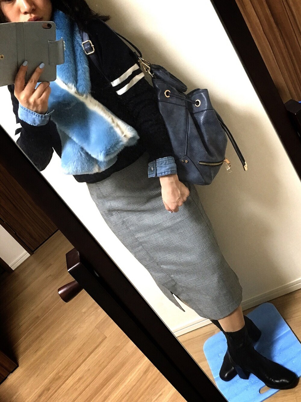 ブルー系のシャツ/ブラウス、ブルー系のニット/セーター、グレー系のスカートを着用したレディースの冬コーディネートの1枚目の写真
