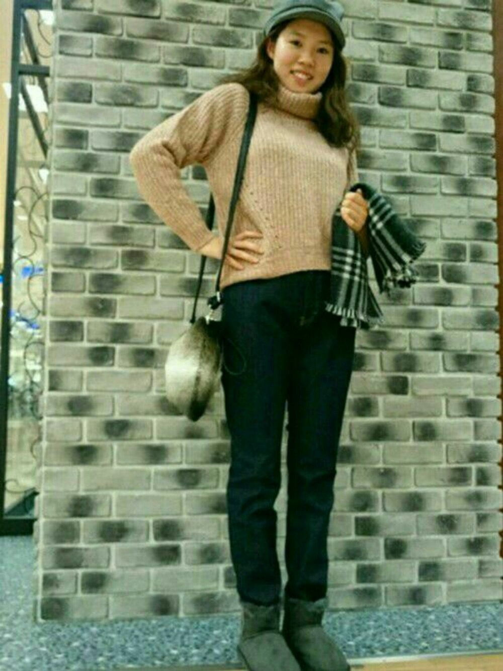 ベージュ系のショルダーバッグ、ピンク系のニット/セーター、ブルー系のデニムパンツを着用したレディースの秋コーディネートの1枚目の写真