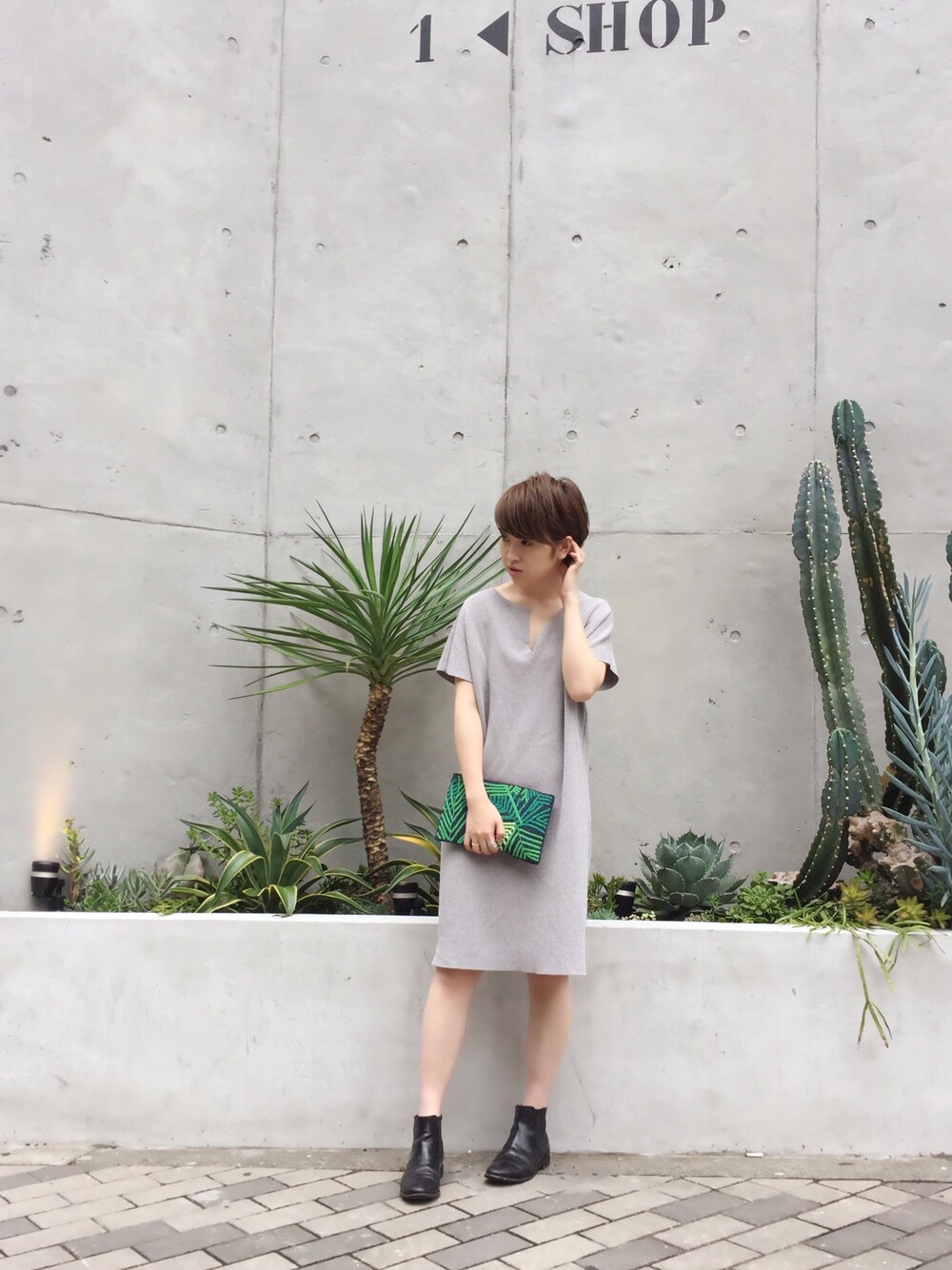 グレー系のワンピース、ブルー系のクラッチバッグを着用したレディースの夏コーディネートの1枚目の写真