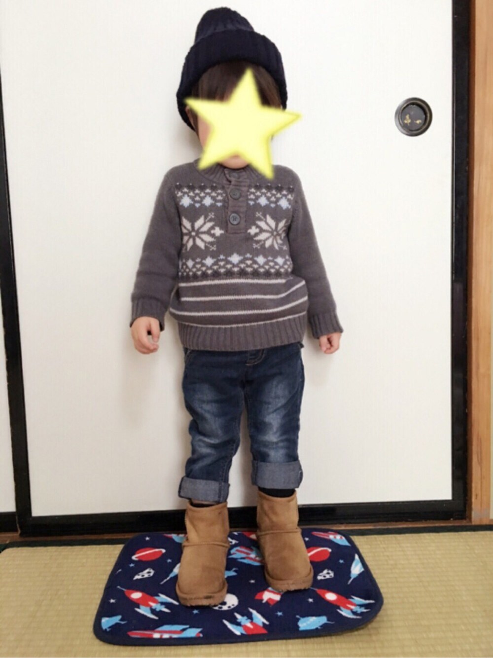 グレー系のニット/セーター、ブルー系のデニムパンツ、ベージュ系のブーツを着用したキッズの冬コーディネートの1枚目の写真