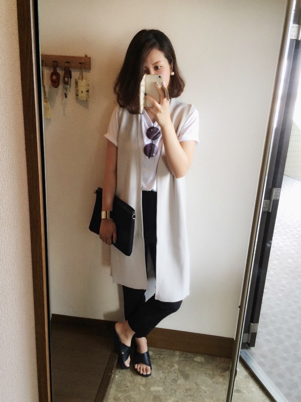 グレー系のベスト、ブラック系のその他パンツ、ブラック系のサンダルを着用したレディースの夏コーディネートの1枚目の写真