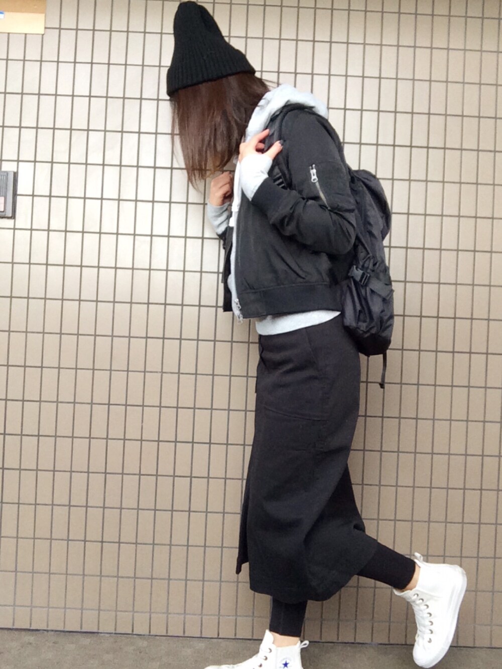 ホワイト系のスニーカー、ブラック系のスカート、グレー系のパーカーを着用したレディースの冬コーディネートの1枚目の写真