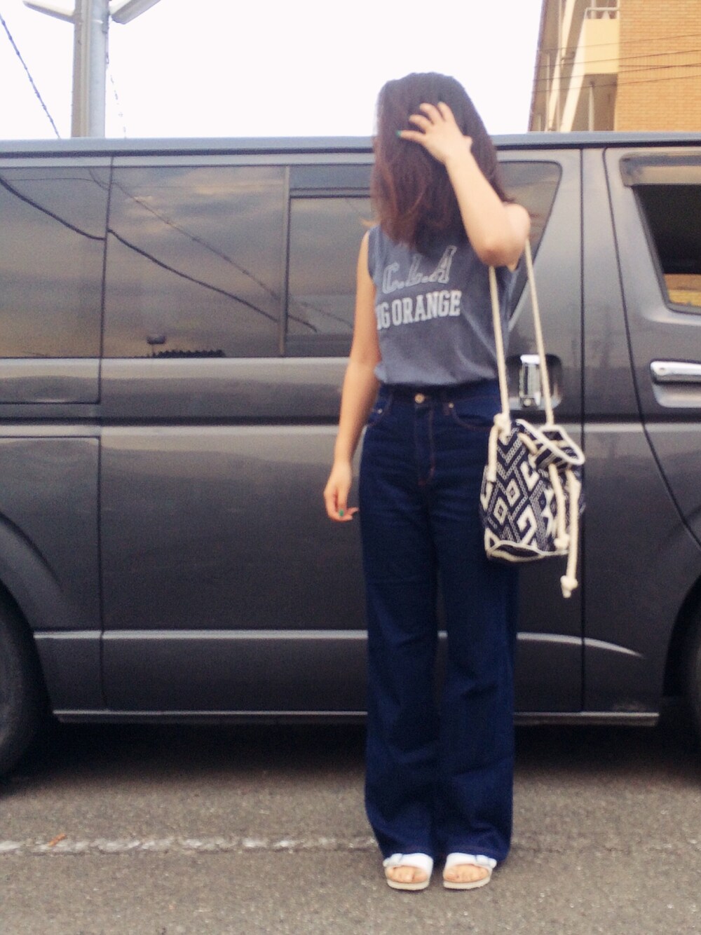 ホワイト系のサンダル、ブルー系のデニムパンツ、ブルー系のタンクトップを着用したレディースの夏コーディネートの1枚目の写真