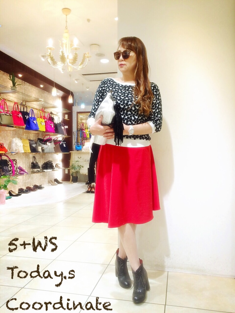 ブラック系のニット/セーター、レッド系のスカート、ブラック系のブーティを着用したレディースの春コーディネートの1枚目の写真