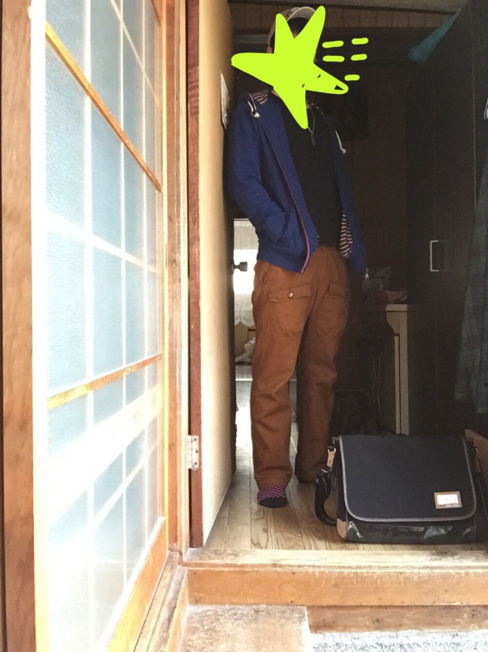 ブラック系のショルダーバッグ、オレンジ系のカーゴパンツ、ブルー系のパーカーを着用したメンズの春コーディネートの1枚目の写真