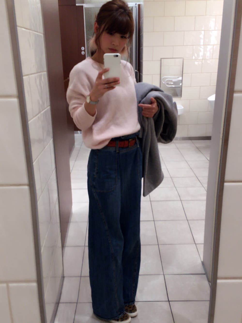 ブルー系のデニムパンツ、ピンク系のニット/セーター、グレー系のチェスターコートを着用したレディースの冬コーディネートの1枚目の写真
