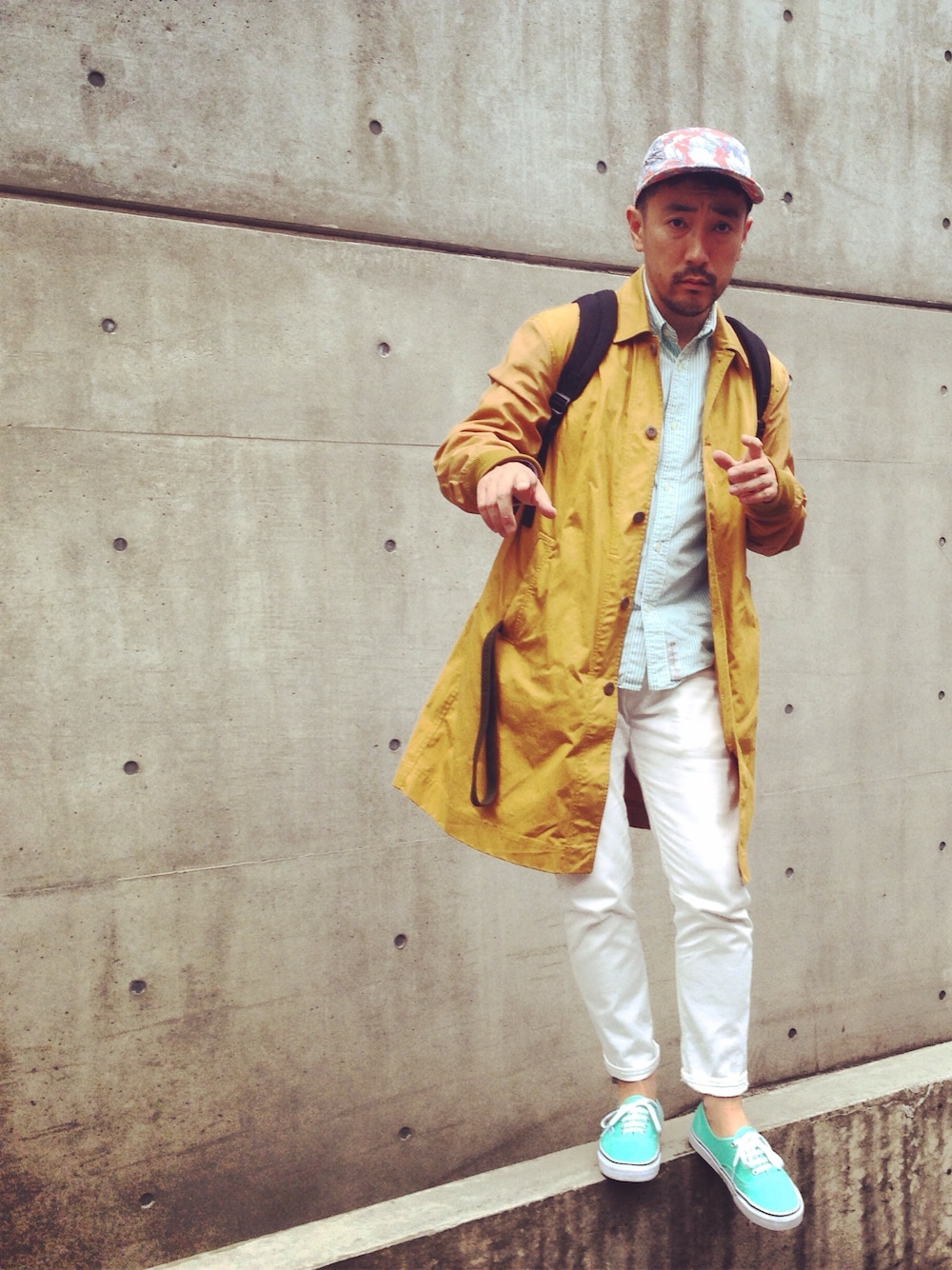 グリーン系のシャツ/ブラウス、イエロー系のステンカラーコート、ホワイト系のデニムパンツを着用したメンズの春コーディネートの1枚目の写真