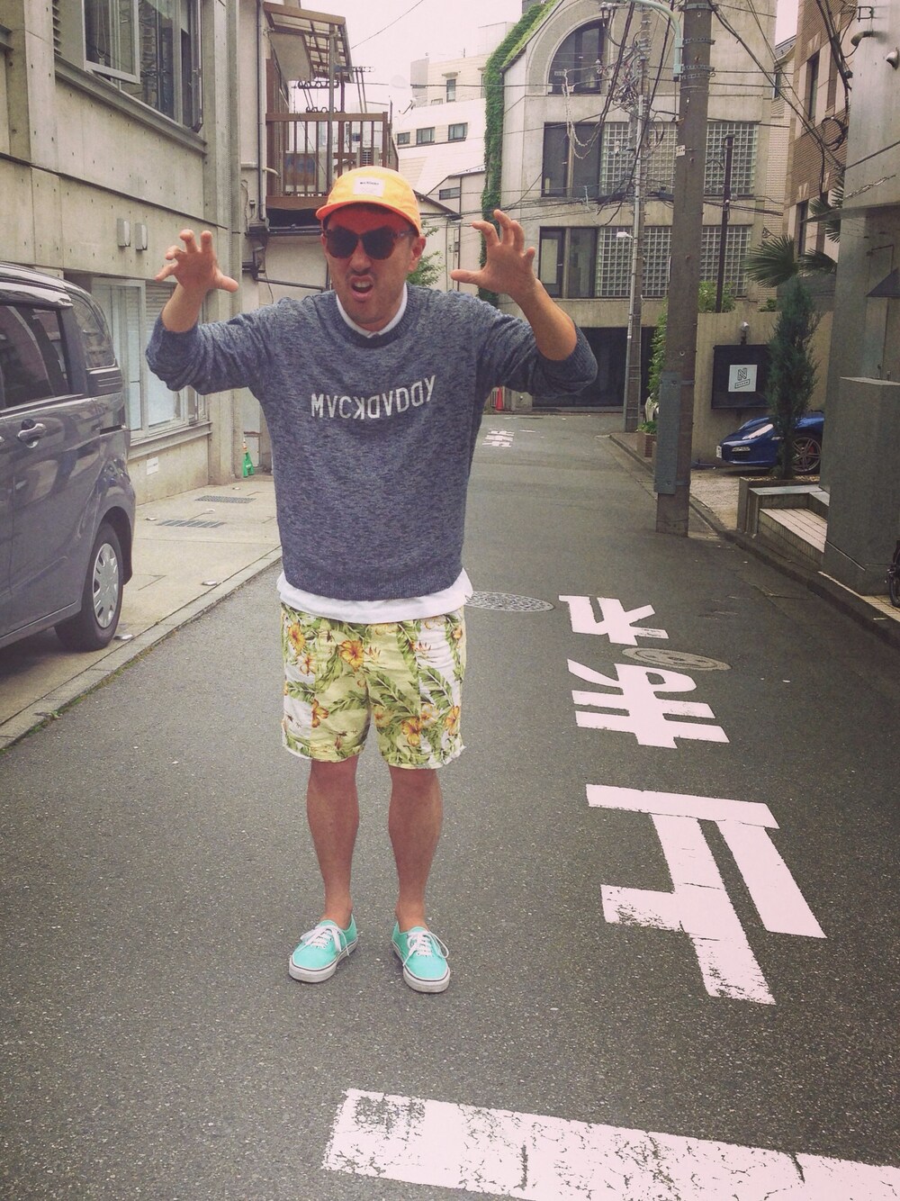 ホワイト系のその他パンツ、ブルー系のニット/セーター、オレンジ系のキャップを着用したメンズの夏コーディネートの1枚目の写真