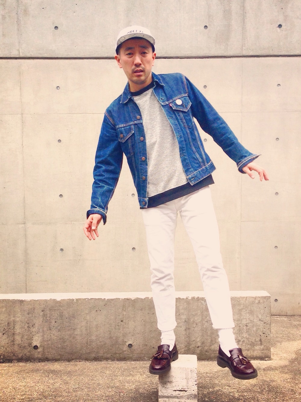 ホワイト系のデニムパンツ、グレー系のスウェット、ホワイト系のキャップを着用したメンズの春コーディネートの1枚目の写真