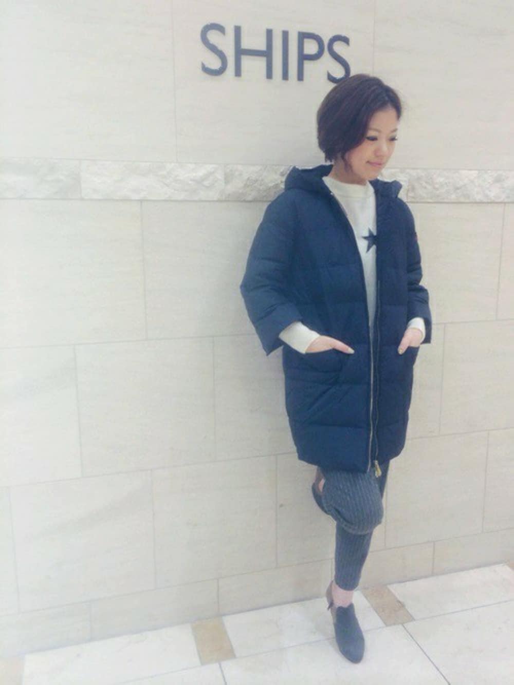 グレー系のその他パンツ、ホワイト系のニット/セーター、グレー系のブーティを着用したレディースの秋コーディネートの1枚目の写真