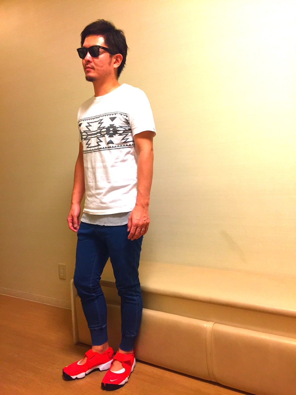 ホワイト系のTシャツ/カットソー、レッド系のスニーカー、ブルー系のパンツを着用したメンズの秋コーディネートの1枚目の写真