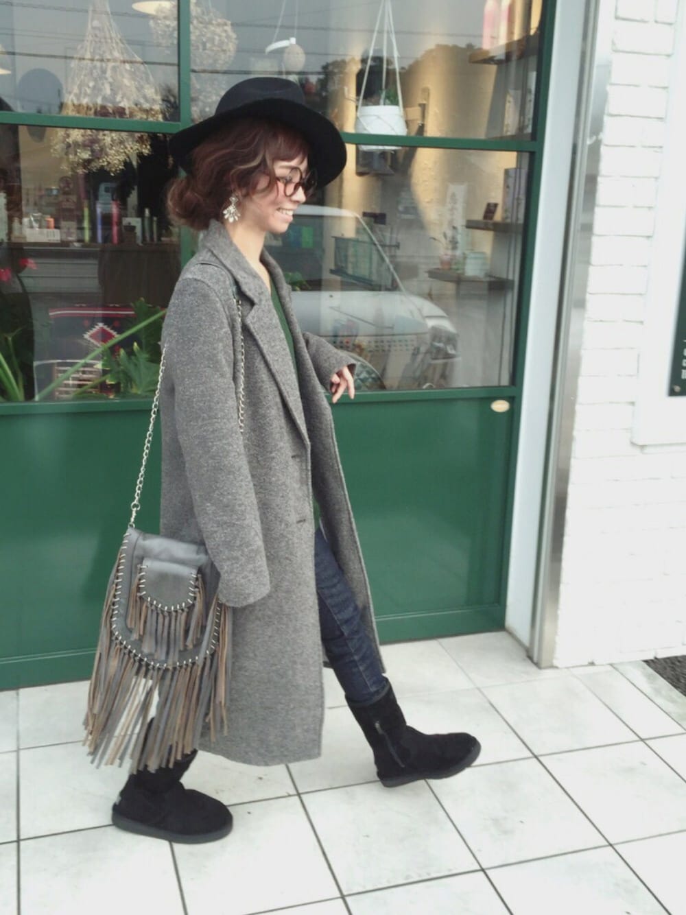 グリーン系のニット/セーター、グレー系のその他アウター、ブラック系のブーツを着用したレディースの冬コーディネートの1枚目の写真