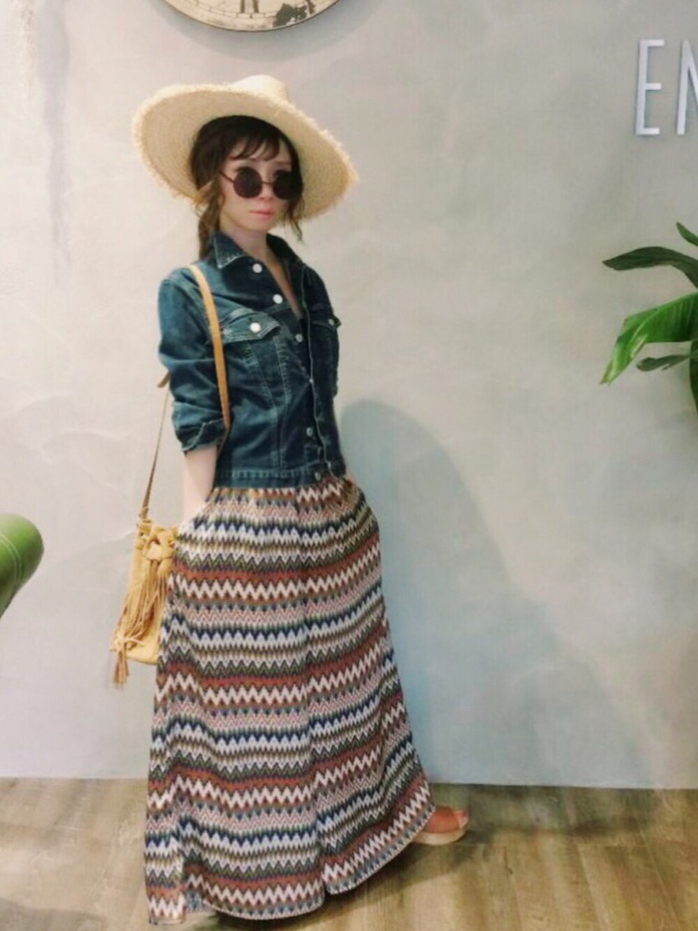 ブルー系のデニムジャケット、ブラウン系のサンダル、イエロー系のショルダーバッグを着用したレディースの春コーディネートの1枚目の写真