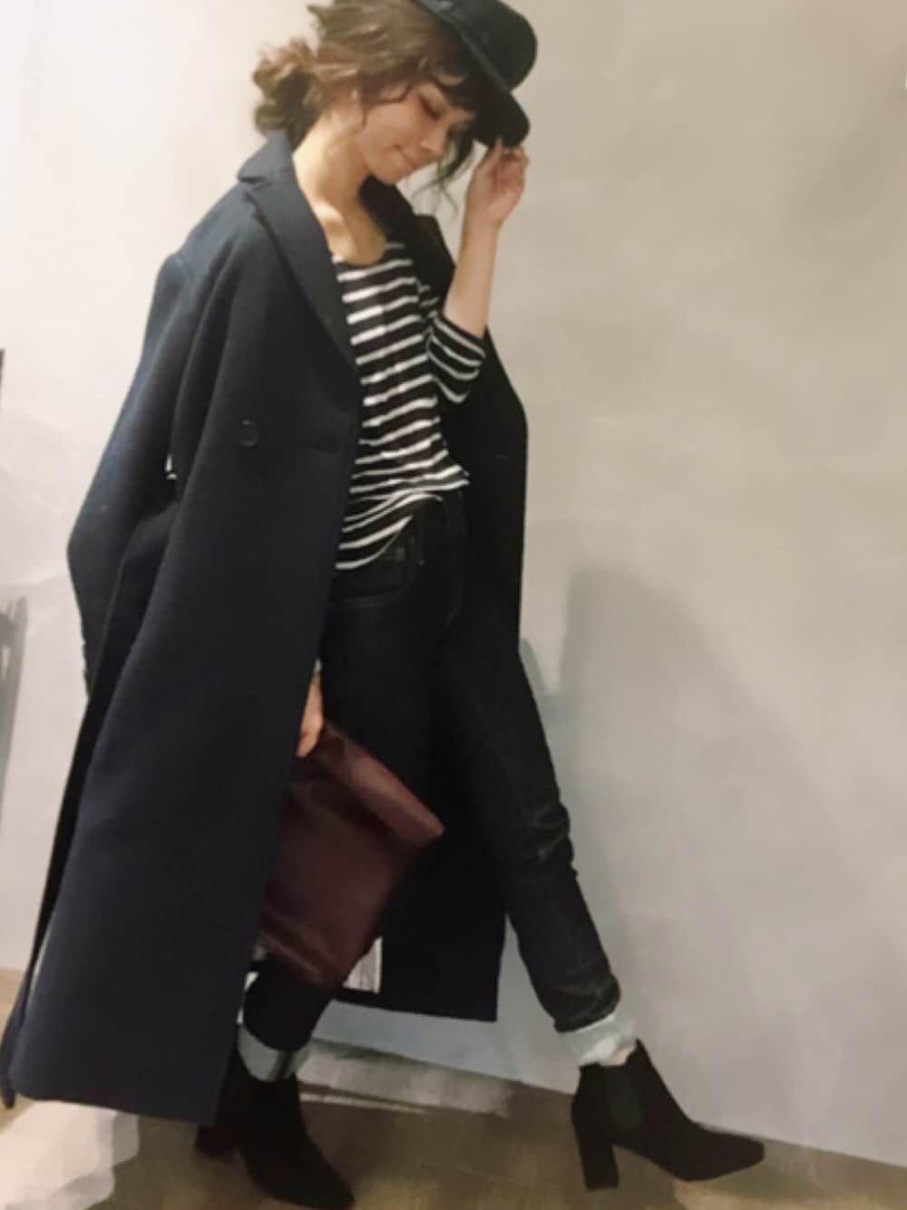 ブルー系のチェスターコート、ブルー系のデニムパンツ、ブラック系のブーツを着用したレディースの秋コーディネートの1枚目の写真