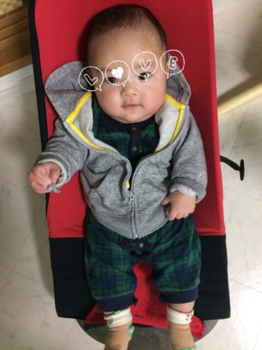 グレー系のパーカー、グリーン系のロンパースを着用したキッズの春コーディネートの1枚目の写真