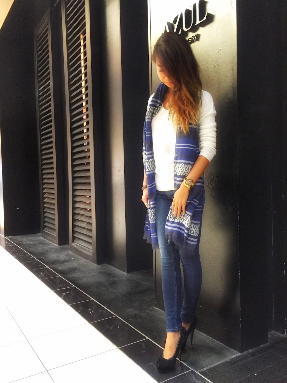 ホワイト系のトップス、ブルー系のデニムパンツ、ブルー系のストール/ショールを着用したレディースの秋コーディネートの1枚目の写真