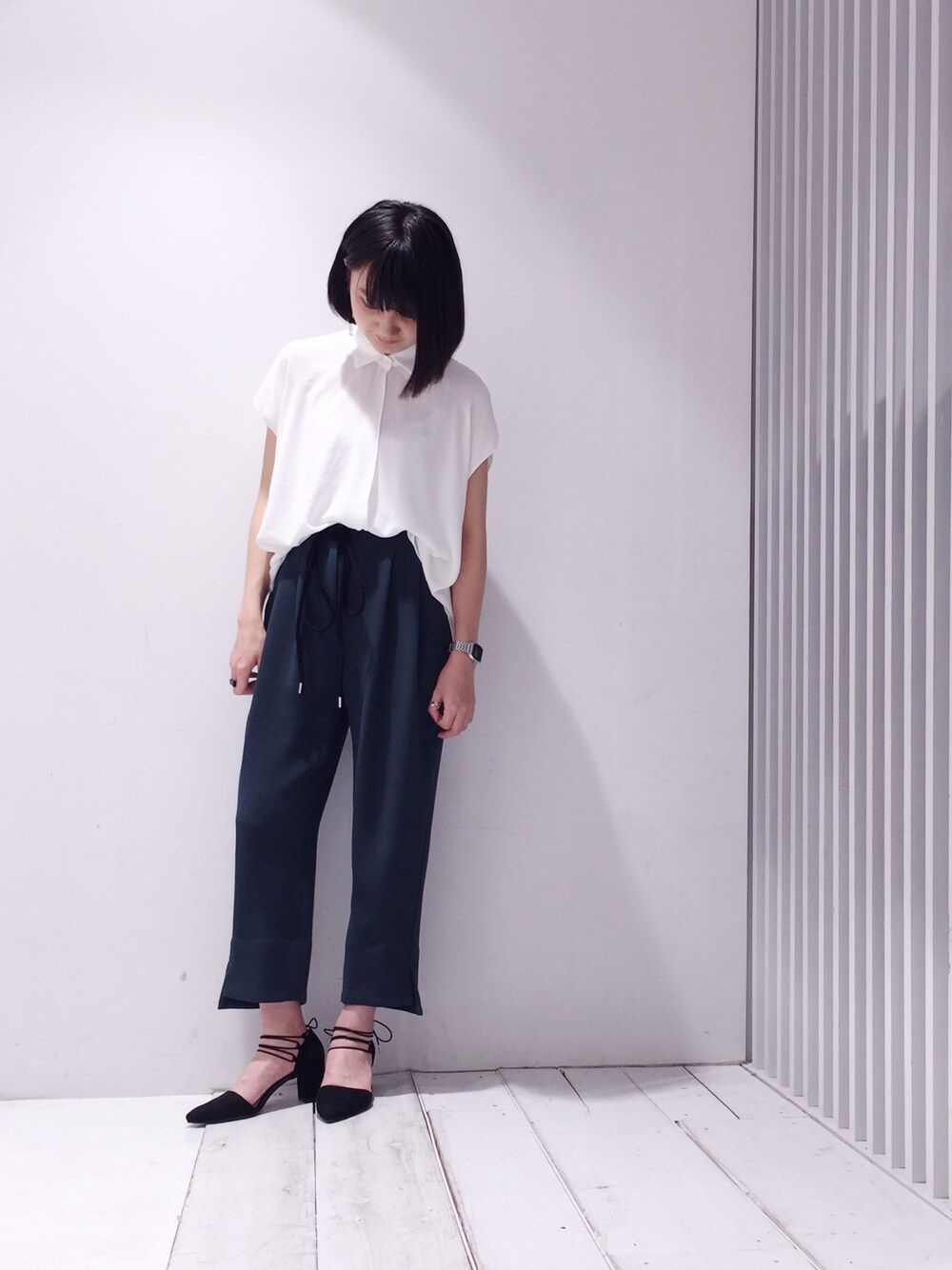 ホワイト系のシャツ/ブラウス、グリーン系のパンツ、ブラック系のパンプスを着用したレディースの春コーディネートの1枚目の写真