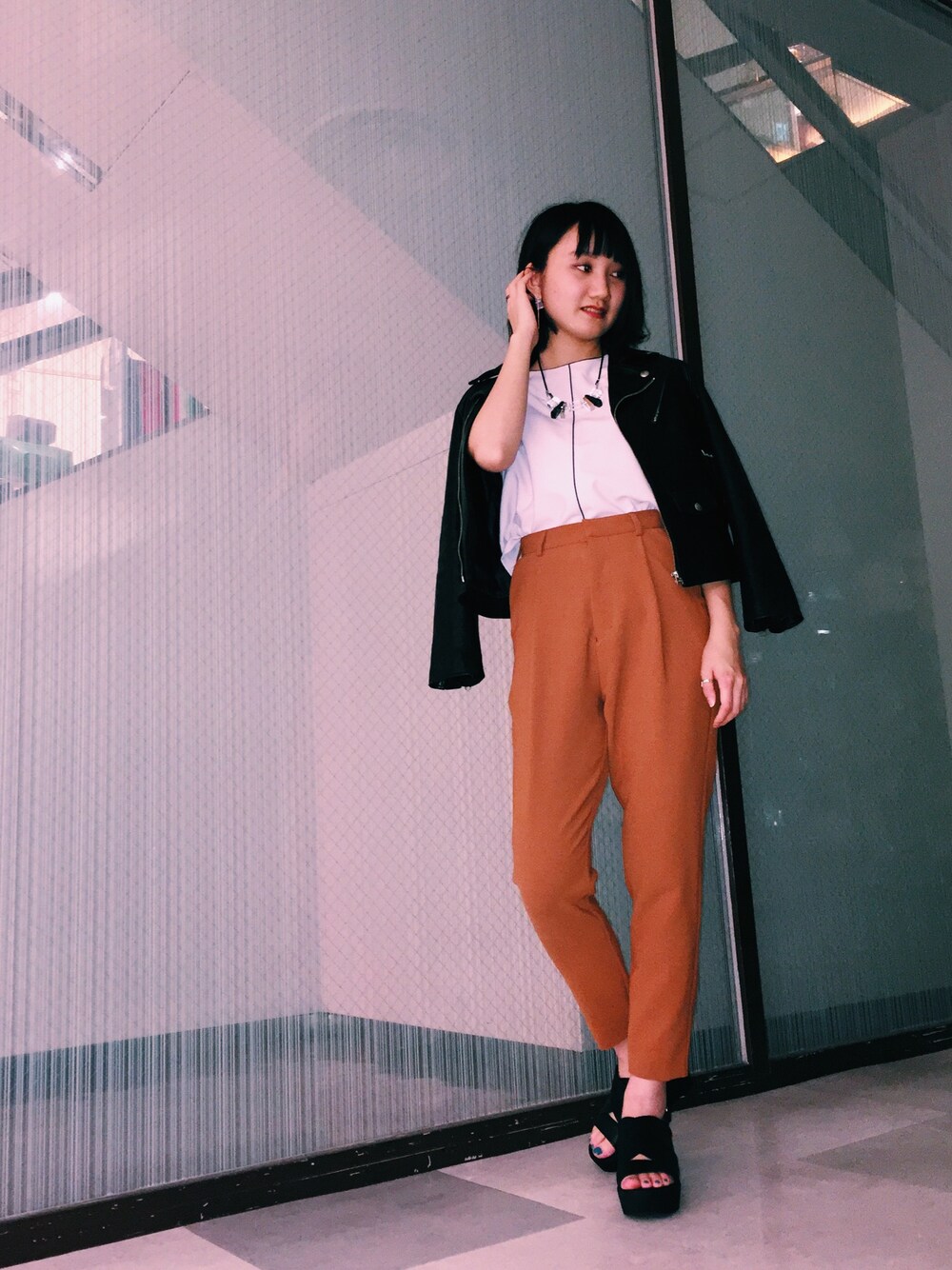 ホワイト系のトップス、オレンジ系のパンツ、ブラック系のサンダルを着用したレディースの夏コーディネートの1枚目の写真