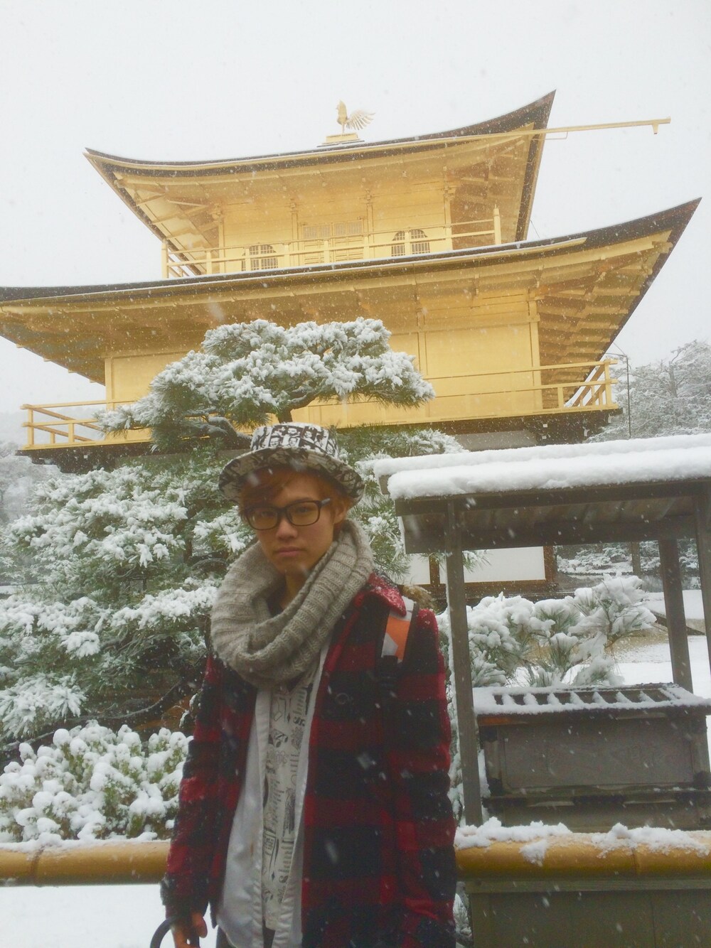 レッド系のピーコート、ホワイト系のハットを着用したメンズの冬コーディネートの1枚目の写真