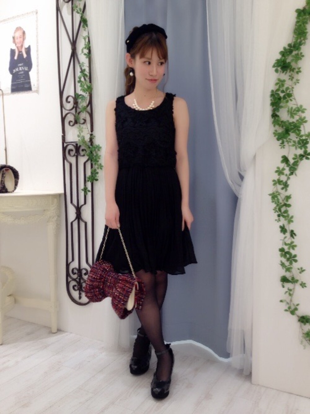 ブラック系のワンピース、ブラック系のパンプス、レッド系のショルダーバッグを着用したレディースの冬コーディネートの1枚目の写真