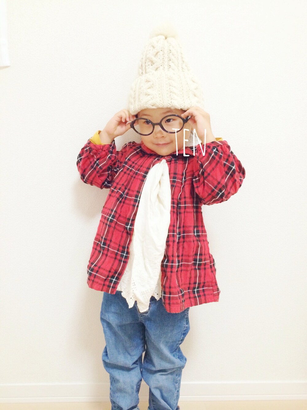 「kids、ポンポン帽子、チェックワンピース、丸メガネ」｜「apres les coursのアイテム（シャツ/ブラウス、レッド系）」を使った、tenpiさん（キッズ・100cm）の秋コーディネートの1枚目の写真