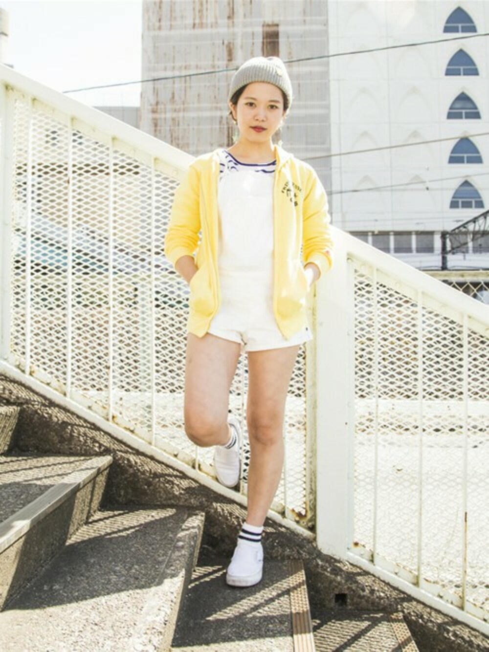 イエロー系のスウェット、ブルー系のTシャツ/カットソー、グレー系のニットキャップ/ビーニーを着用したレディースの春コーディネートの1枚目の写真