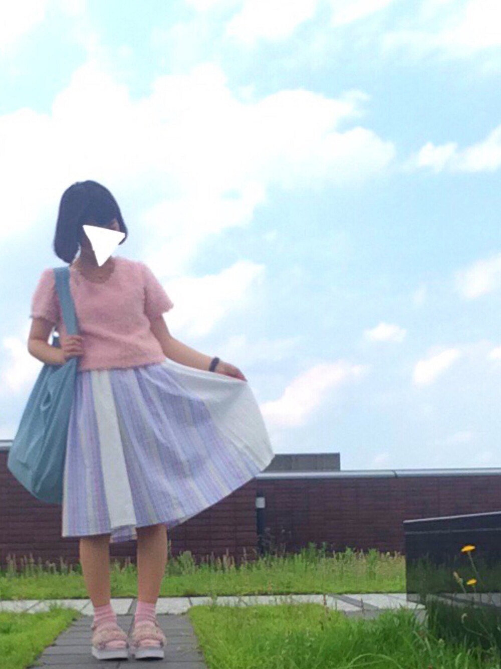 ピンク系のトップス、ブルー系のスカート、ブルー系のショルダーバッグを着用したレディースの夏コーディネートの1枚目の写真