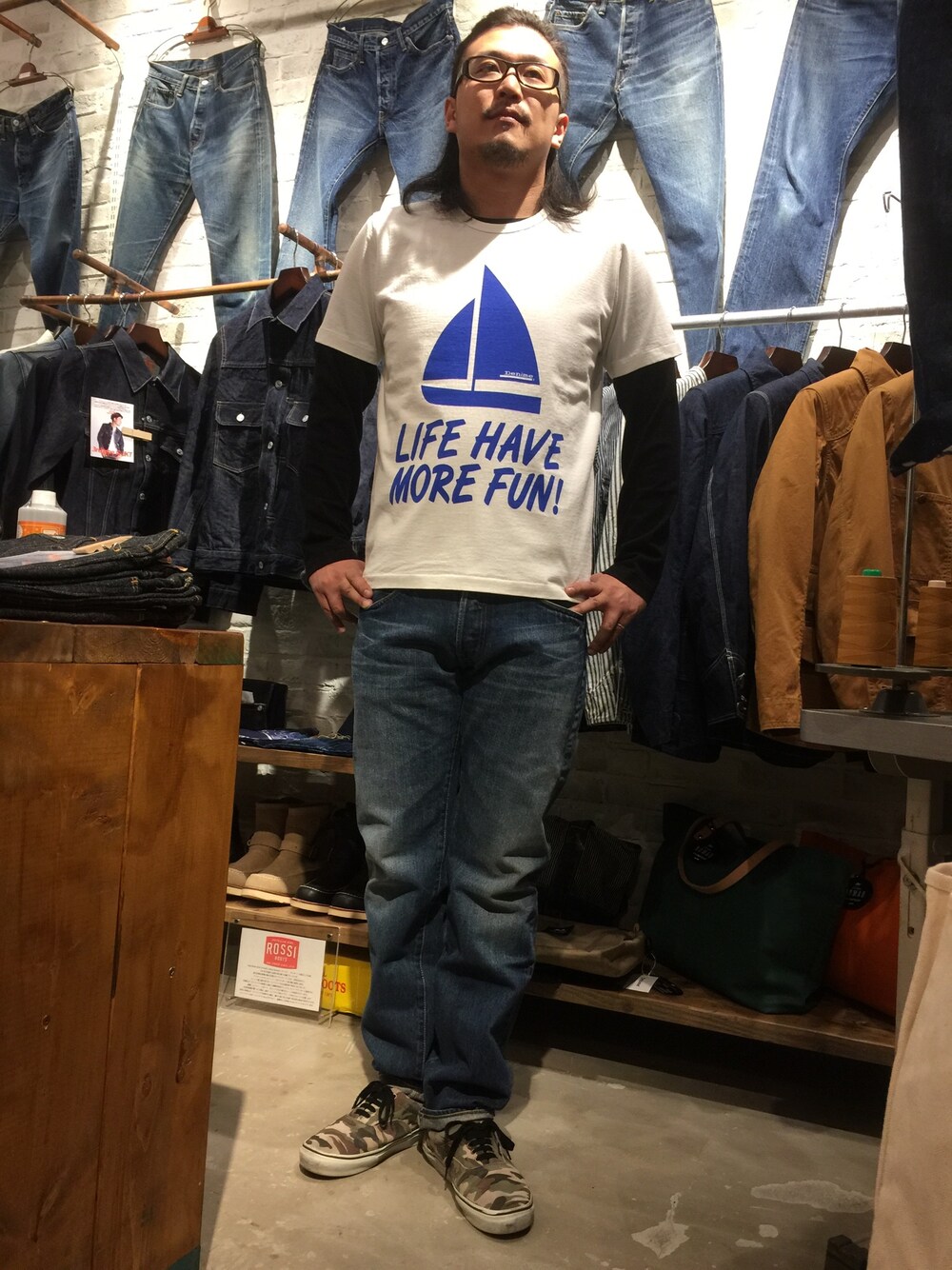 ホワイト系のTシャツ/カットソー、ブルー系のデニムパンツ、グリーン系のスニーカーを着用したメンズの春コーディネートの1枚目の写真