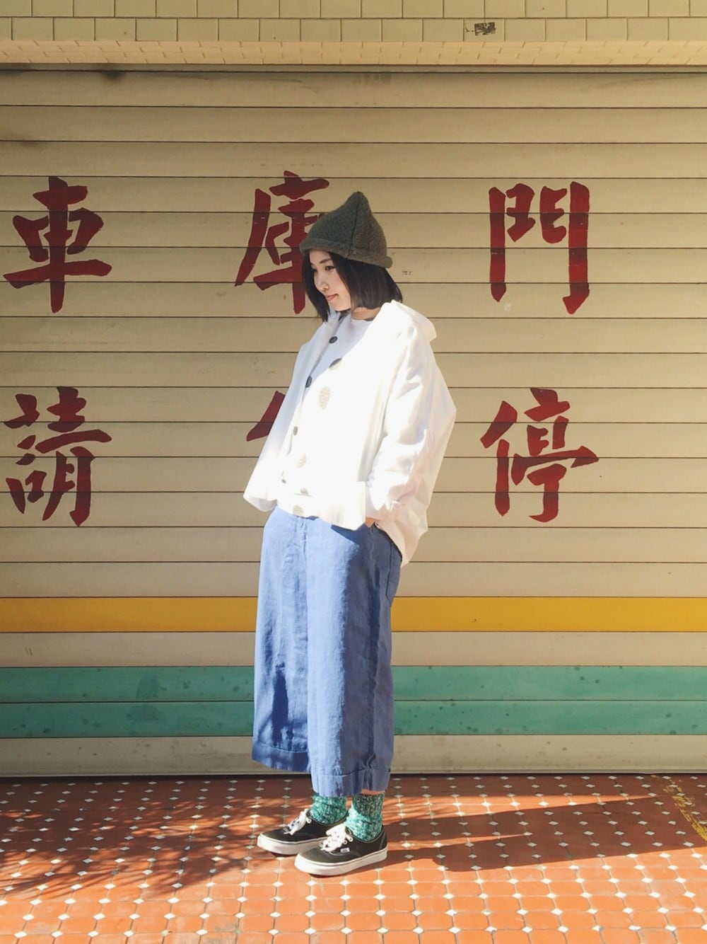 ホワイト系のトップス、ブラック系のシューズ、ブルー系のパンツを着用したレディースの春コーディネートの1枚目の写真