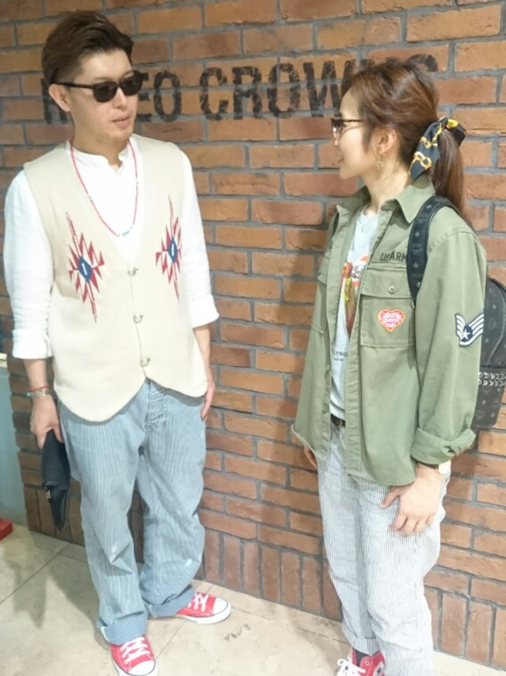 グリーン系のミリタリージャケット、グレー系のTシャツ/カットソー、ブラック系のバックパック/リュックを着用したレディースの春コーディネートの1枚目の写真