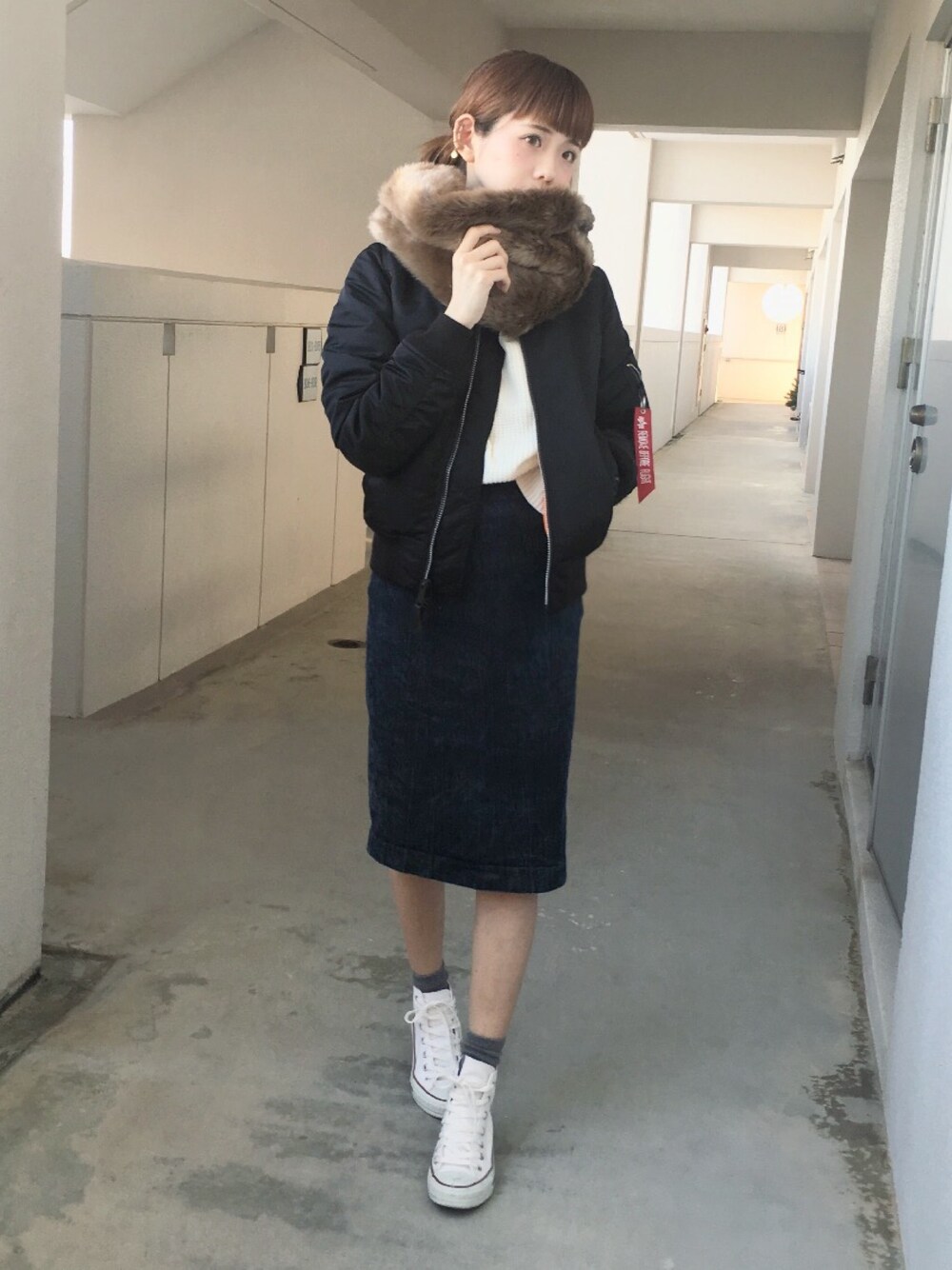 ブラック系のMA-1、ホワイト系のニット/セーター、ホワイト系のスニーカーを着用したレディースの秋コーディネートの1枚目の写真