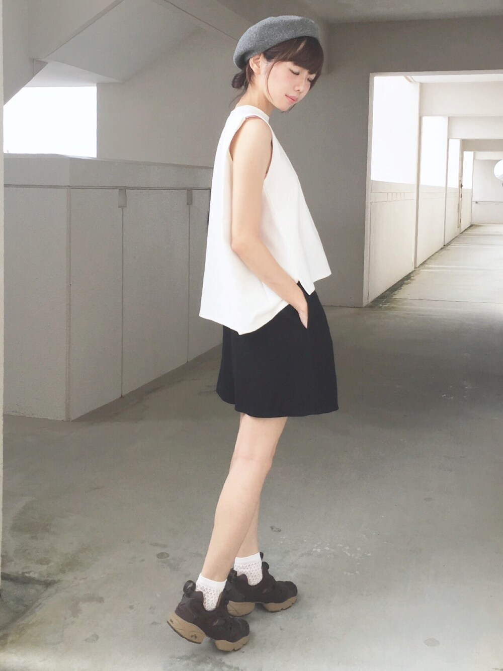 ホワイト系のTシャツ/カットソー、ブラック系のスカート、ブラウン系のスニーカーを着用したレディースの夏コーディネートの1枚目の写真