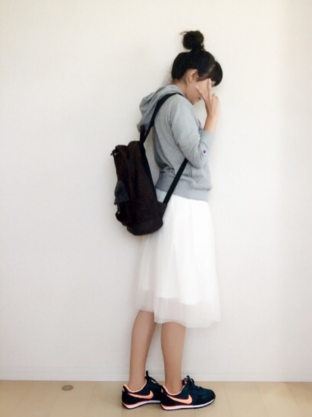 ホワイト系のスカート、ブラウン系のバックパック/リュック、グレー系のパーカーを着用したレディースの秋コーディネートの1枚目の写真