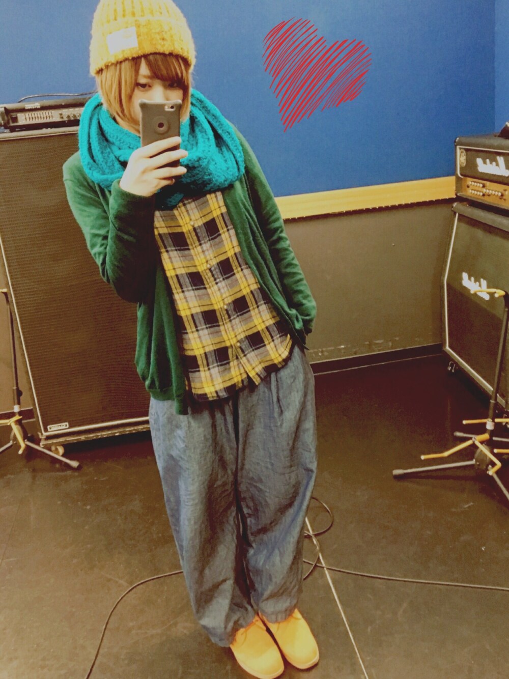 グリーン系のニット/セーター、イエロー系のシャツ/ブラウス、ブルー系のパンツを着用したレディースの秋コーディネートの1枚目の写真