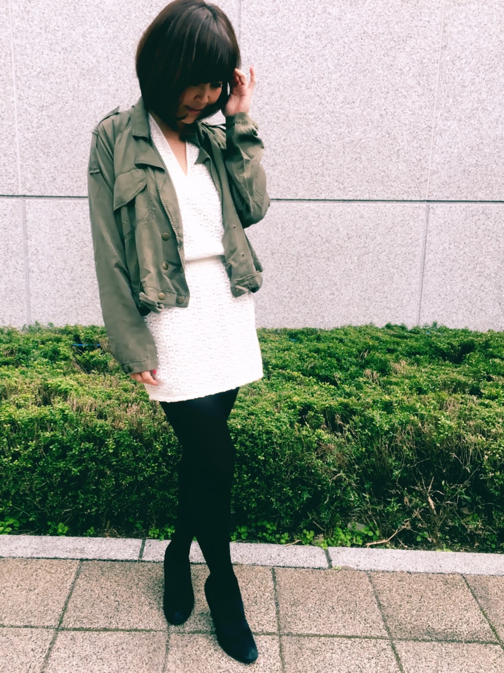 ホワイト系のワンピース、グリーン系のブルゾンを着用したレディースの春コーディネートの1枚目の写真
