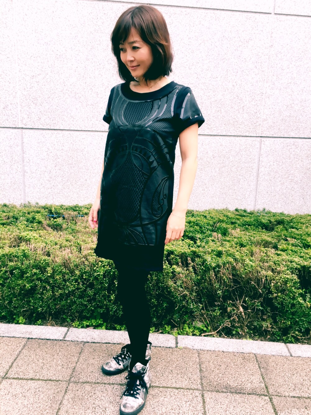 ブラック系のチュニックを着用したレディースの春コーディネートの1枚目の写真