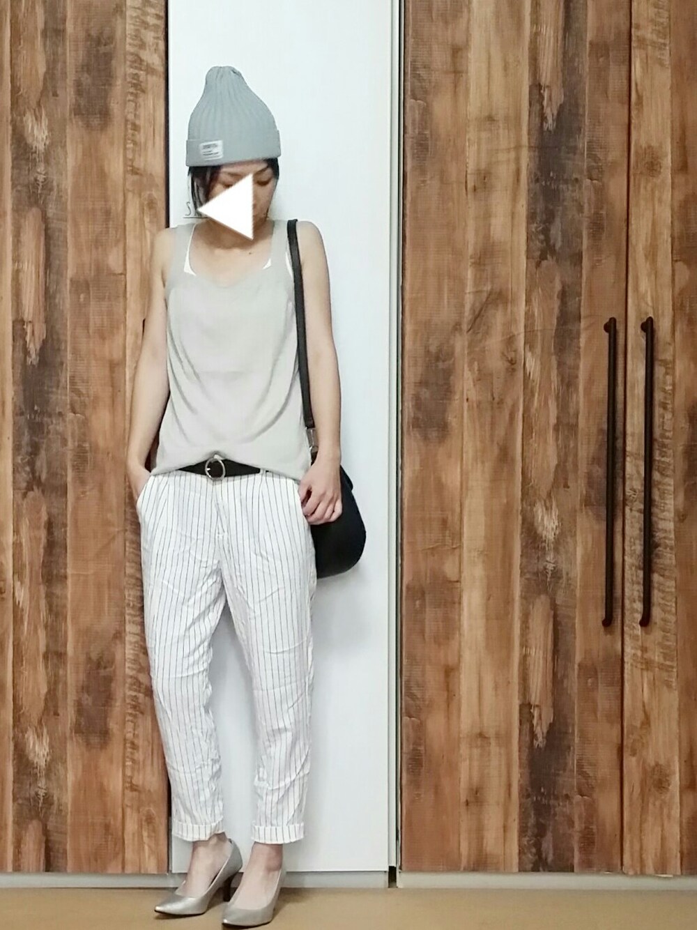 ホワイト系のパンツ、シルバー系のシューズ、ブラック系のショルダーバッグを着用したレディースの夏コーディネートの1枚目の写真