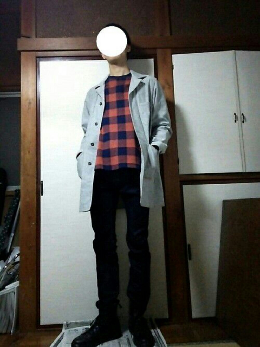 オレンジ系のTシャツ/カットソー、ブルー系のデニムパンツ、ブラック系のブーツを着用したメンズの秋コーディネートの1枚目の写真