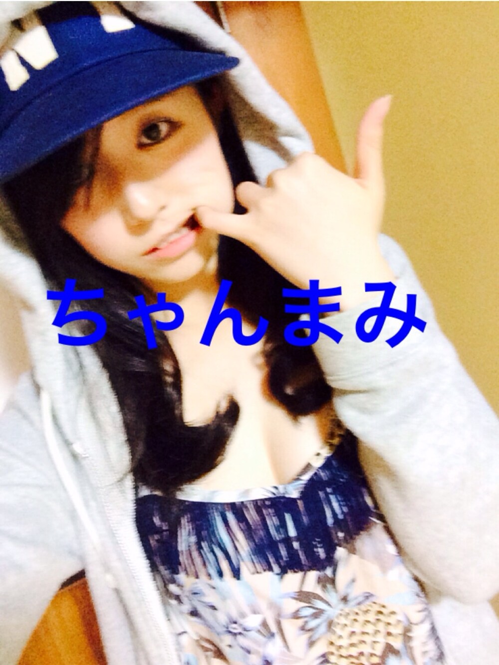 ベージュ系のキャミソール、ブルー系のキャップを着用したレディースの夏コーディネートの1枚目の写真