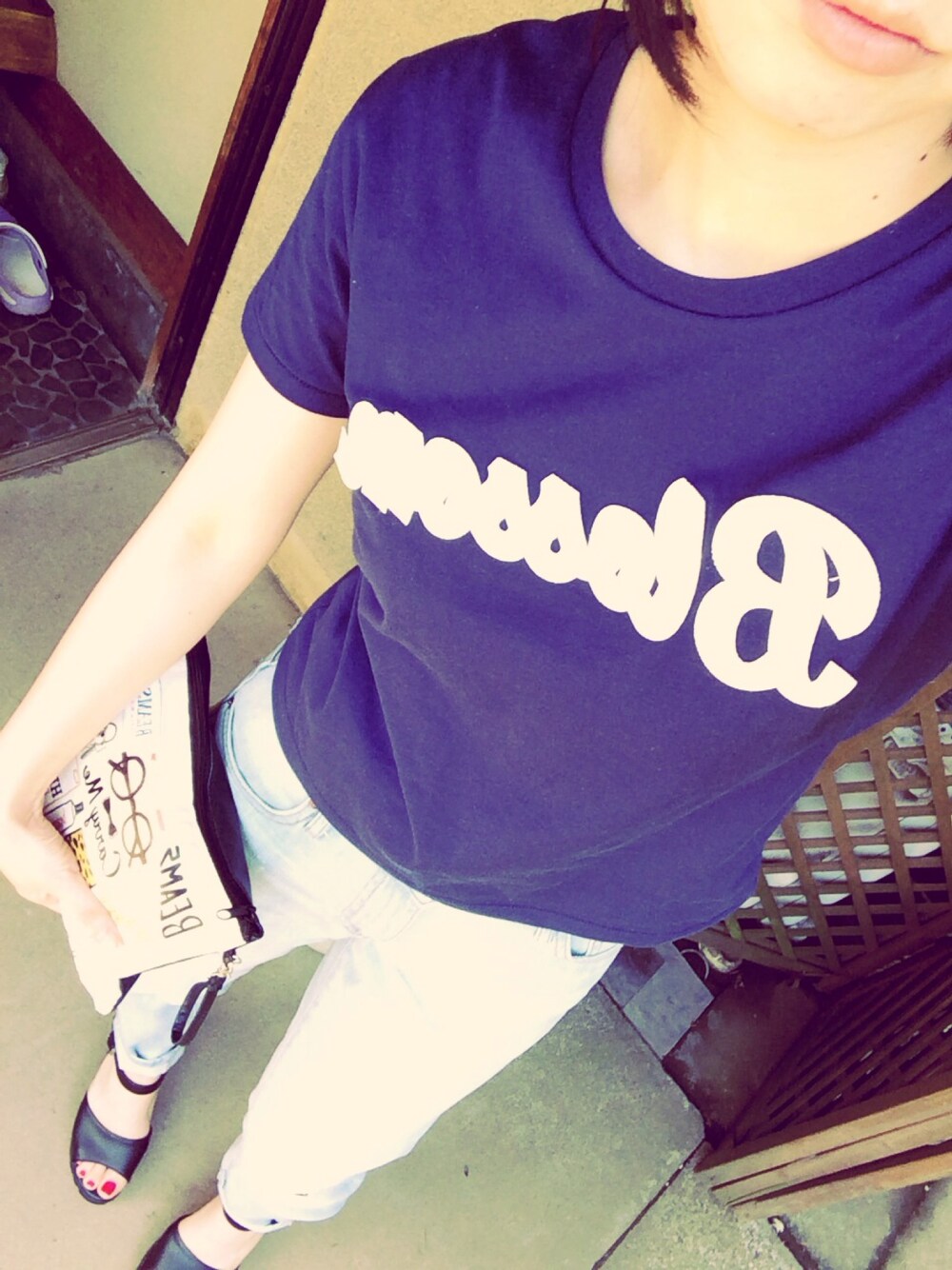 ブルー系のTシャツ/カットソー、ブルー系のデニムパンツ、ホワイト系のクラッチバッグを着用したレディースの春コーディネートの1枚目の写真