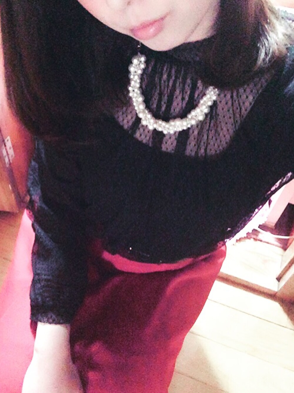 レッド系のスカート、レッド系のパンプス、ブラック系のシャツ/ブラウスを着用したレディースの春コーディネートの1枚目の写真