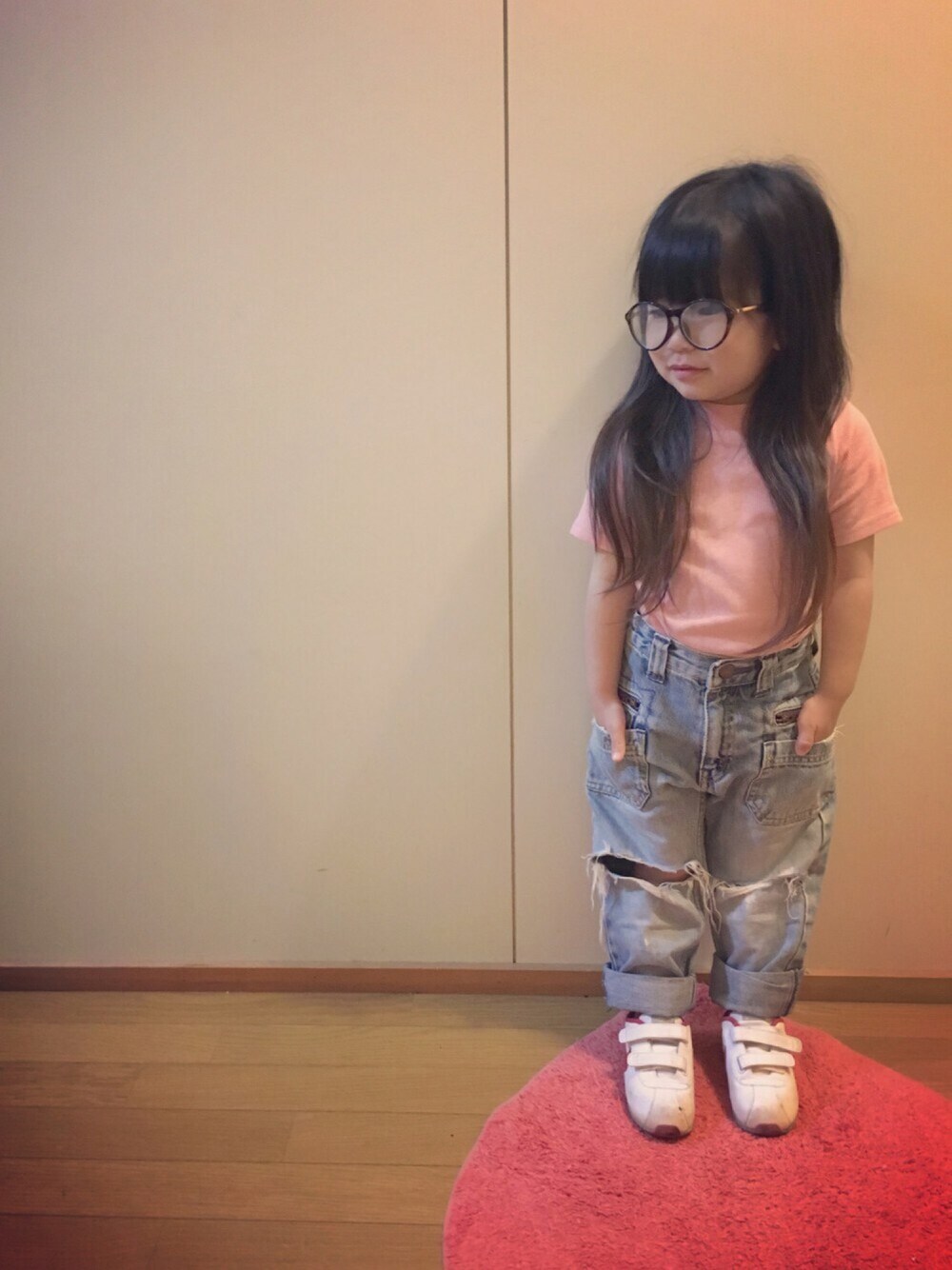 ピンク系のTシャツ/カットソー、ブルー系のデニムパンツ、レッド系のスニーカーを着用したキッズの春コーディネートの1枚目の写真